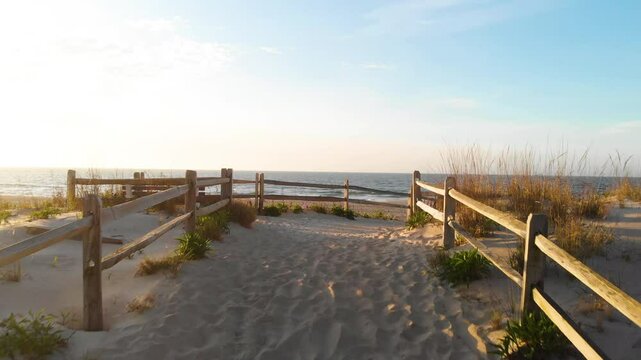 Drone view of a path on a sand dune and a beach by an ocean