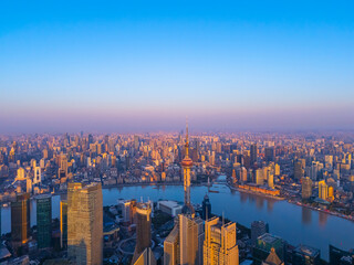Aerial view of Shanghai skyline with winding river at sunrise.