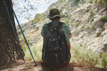 Backpacker Resting Under a Tree During a Mountain Hiking Adventure