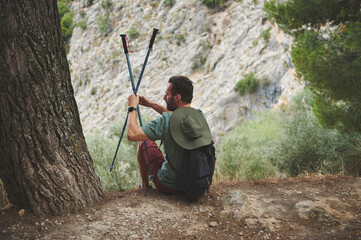 Man Relaxing with Hiking Poles Outdoors in Scenic Mountain Environment