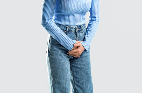 Medical or gynecological problems, healthcare concept. Woman covering his crotch with both hands. Sick woman hands holding pressing her crotch lower abdomen