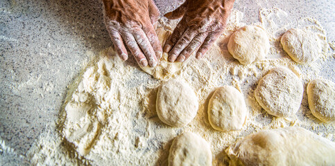 Homemade cakes dough in the women's hands. Process of making pies, hand. Hands pie dough. Cooks dough for baking, pieces of raw dough. Womans hands rolling doughs for pies. Baking at home