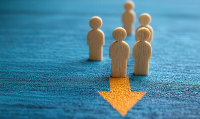 Wooden figures in a line with a downward arrow