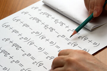 Engaging in mathematics practice at a wooden table in daytime