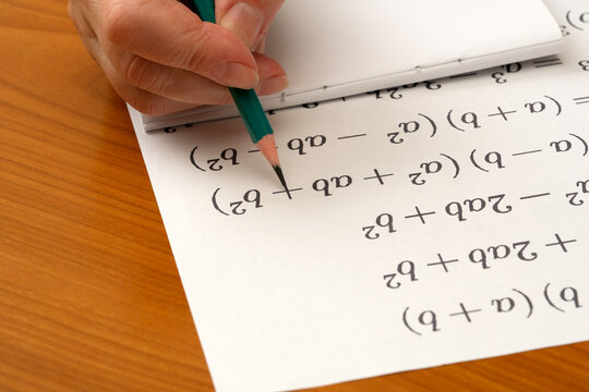 Writing mathematical equations on paper at a study desk