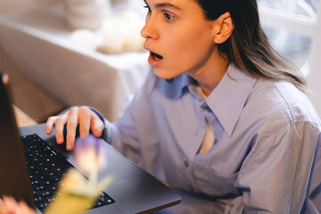 Young shocked businesswoman annoyed unpleasant spam message, open mouth, unexpected news, looking...