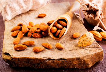 Fragrant roasted almonds with kitchen utensils on a stone table