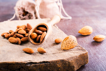 Fragrant roasted almonds with kitchen utensils on a stone table