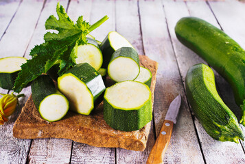 Slicing zucchini on a cutting board. Ripe zucchini. Top view, horizontal.