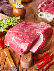 Raw meat on cutting board, with herbs, spices on cooking table top view copy space