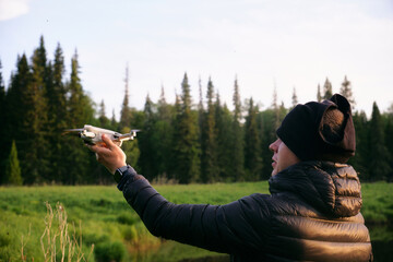 a man launches a drone from his hand. The pilot holds the taking off drone in his hands