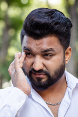 South asian man having vision problem, eye irritation, red eye, dry eye or eye inflammation, optical or eye health care concept