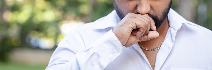 Unwell South Asian young adult man suffering from cold or flu with allergic runny nose, nasal viral infection, dust allergy, air pollution, bad smell, stinky pungent smell, nose closeup shot