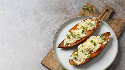 Baked sweet potatoes with ricotta and fresh herbs. Healthy and vegan food. Copy space