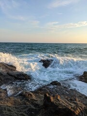 Waves Crashing Against Coastal Rocks at Sunset