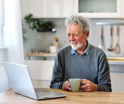 Female caregiver with senior woman and man using laptop at home - Powered by Adobe