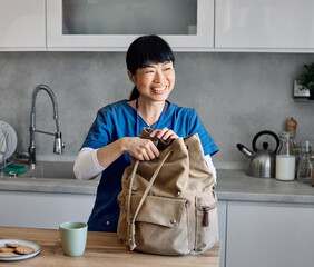 Portrait of a young asian nurse woman gettyng ready for work drinking a glass of water for...