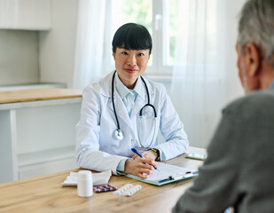 Portrait of a young asian doctor and patient at doctor's office in clinic