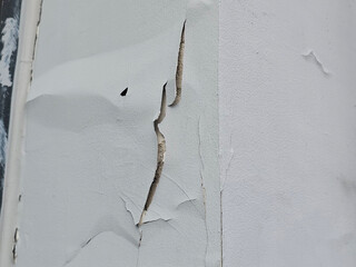 The paint is peeling on texture of the wall building
