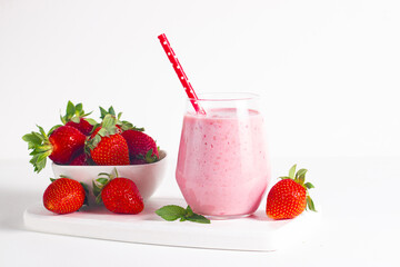 A glass of fresh strawberry smoothie on a white background. Summer drink shake, milkshake and refreshment organic concept.