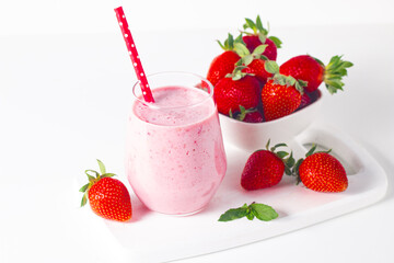 A glass of fresh strawberry smoothie on a white background. Summer drink shake, milkshake and refreshment organic concept.