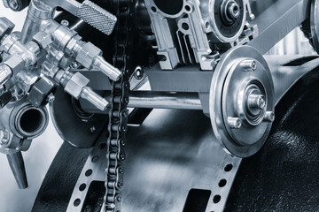 chain is attached to a red engine. The chain is made of metal and is attached to engine blue tone...