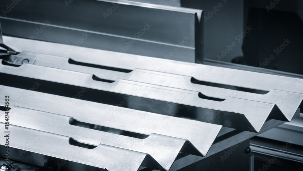Poster metal pieces are being cut by machine blue tone. pieces all same size and shape, and they are arrang
