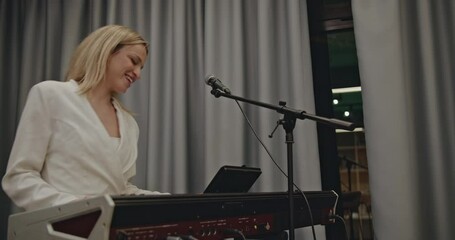 A female keyboardist practices before a concert, showcasing her talent and passion for music in a rehearsal setting.