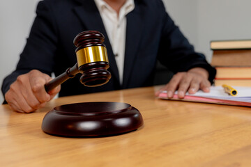 Selective focus on judge’s hand with gavel, symbolizing legal authority in business decision-making.