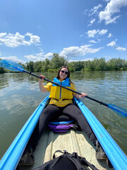 Woman Kayaking on a Calm River. Peaceful Outdoor Adventure.