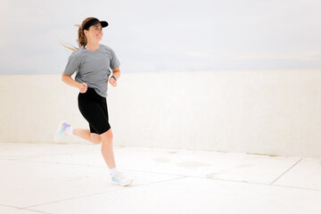 Morning jog on a bright day at an empty coastal promenade with a determined runner savoring the...