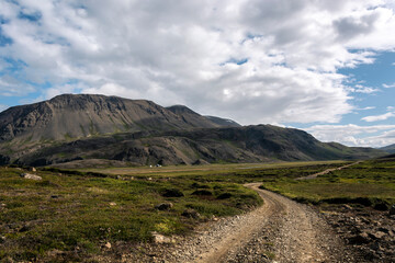Landscape of Iceland with mountains, road and blue sky with clouds