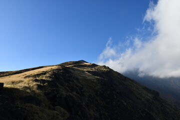 Serene Mountain Landscape Under Clear Blue Sky with Clouds