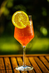 Aperol Sprizz mit Orangenstück  auf Gartentisch