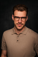 Portrait of a handsome young man standing against isolated black background