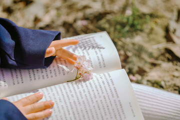 Child reading a book with flowers in a serene setting Chinese word means flower.