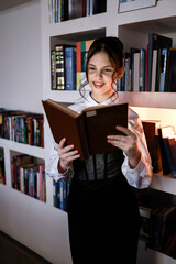 Happy girl with a book in the library.