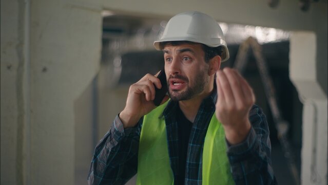 Annoyed Caucasian man contractor holding mobile phone speaking remote call conflict in construction builder foreman arguing furious guy technician building industry working problem upset male argument - Powered by Adobe