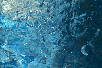 Blue transparent sea surface with bubbles water background