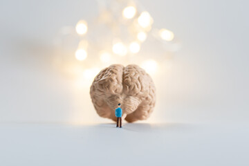 脳の模型とミニチュアの男性と光