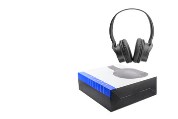 close up of black wireless stereo headphones and paper box on white background