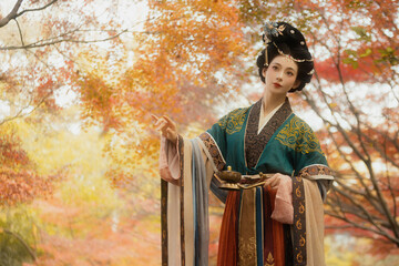 Elegant Asian woman in traditional attire among autumn leaves Chinese word means autumn.