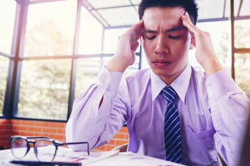 Businessman suffering headache from business disappointed and seriously by bad business results.
