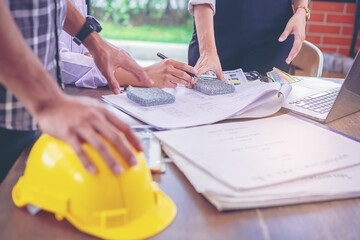 Contractor and engineer with blueprints discuss, choosing materials at a modern construction site, Engineers in mechanical factory reading instructions at construction site office.