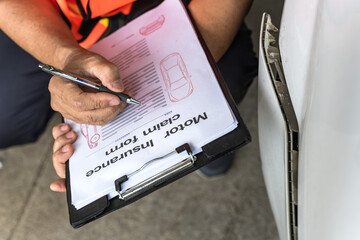 Close up unknown car insurance agent man checking damage lists on car claim document 