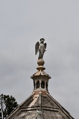 Majestic Angel Statue Towering Over a Historic Building Under a cloudy Sky