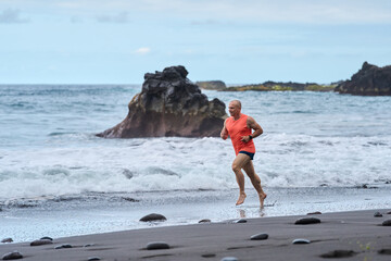 Man running on the black sand beach