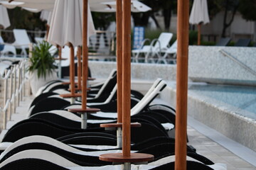 Serene Poolside Lounge Chairs with Umbrellas for Relaxation in dusky light