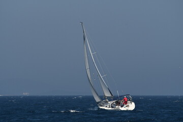 Sailing Adventure: A White Yacht Navigating Calm Blue Waters Under Blue sky