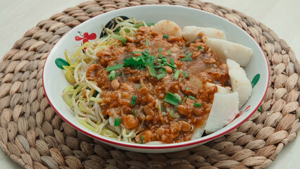 Hearty Asian Noodles with Savory Minced Meat Sauce and Fish Cakes on a Woven Mat
